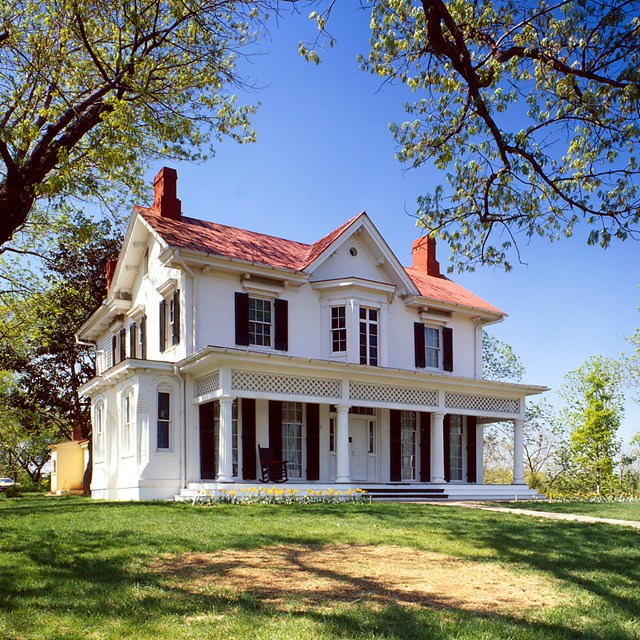 A white panted house with gabled roof.