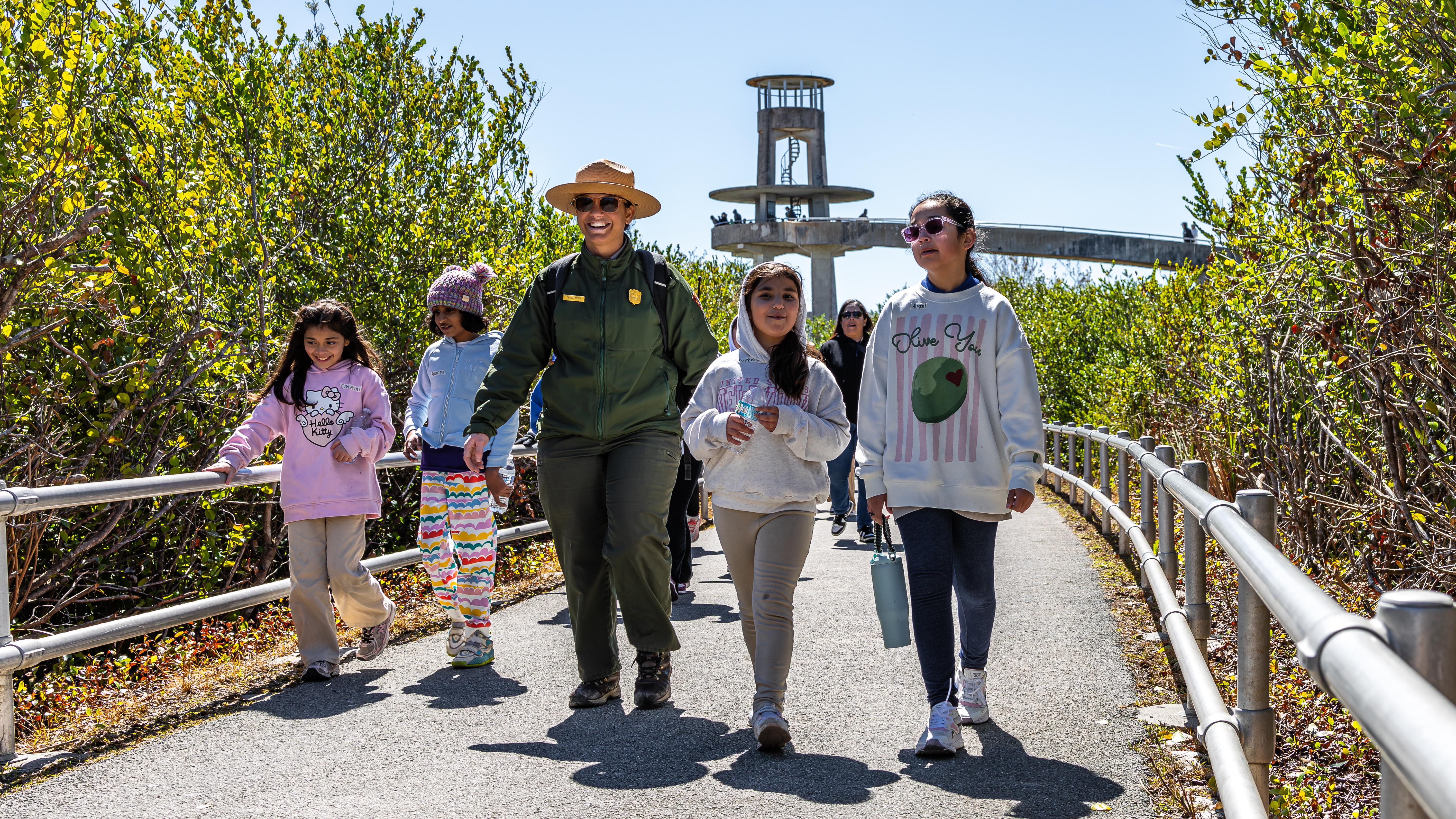 Park ranger smiling at camera with students. 