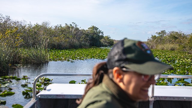 A person smiles while on an airboat.