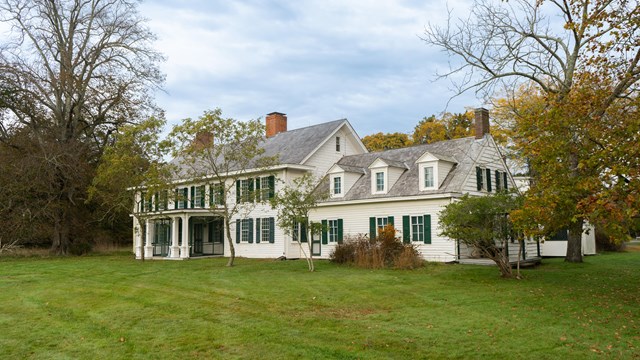 Old Mastic House and woods in fall colors.