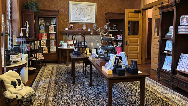 tables and bookcases display various items for sale in the park shop 