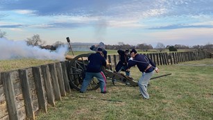 Actors clothed as soldiers reenacting the firing of artillery during the Civil War