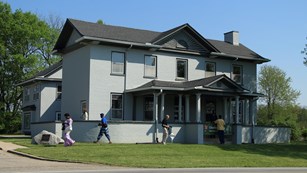 Visitors walking outside of a historic home