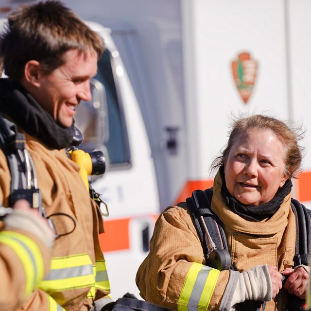 NPS firefighters smile and discuss fire safety