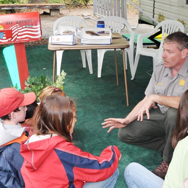 Ranger talks with a group of children about fire prevention