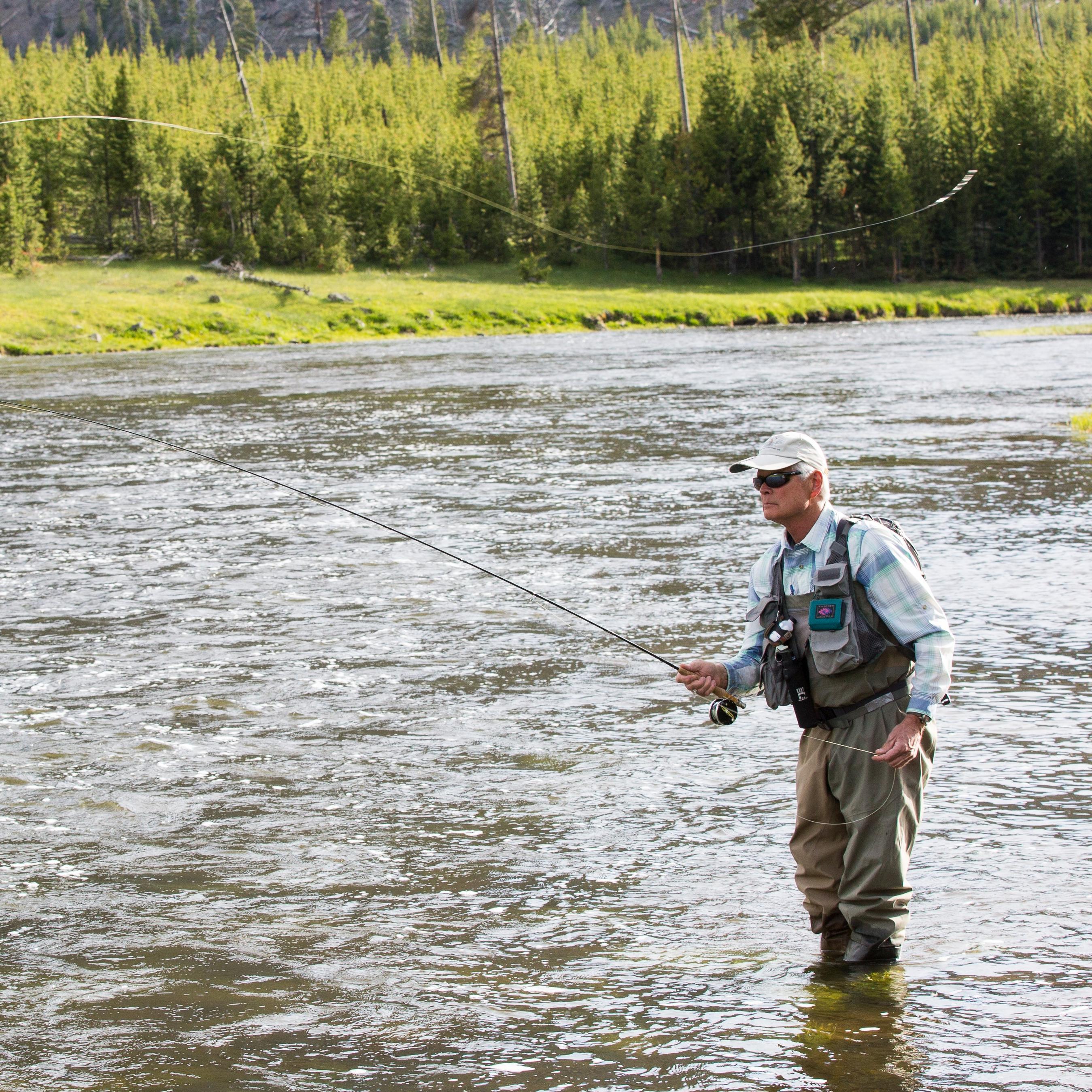 Man casting line into middle of stream