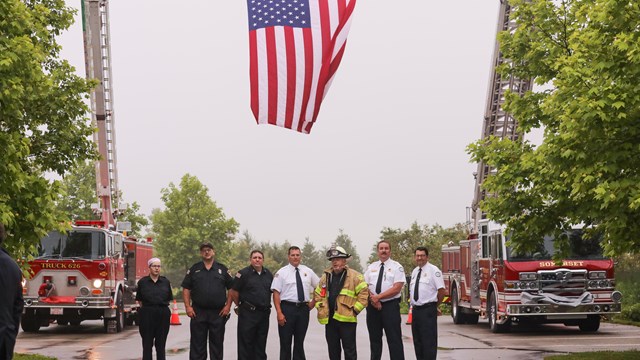 First responders posing under the American flag at the Wreckage Burial event at Flight 93.