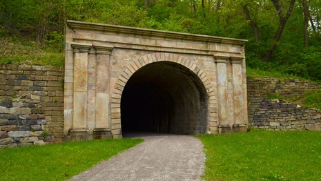 Stone arch tunnel entrance looking into darkness.