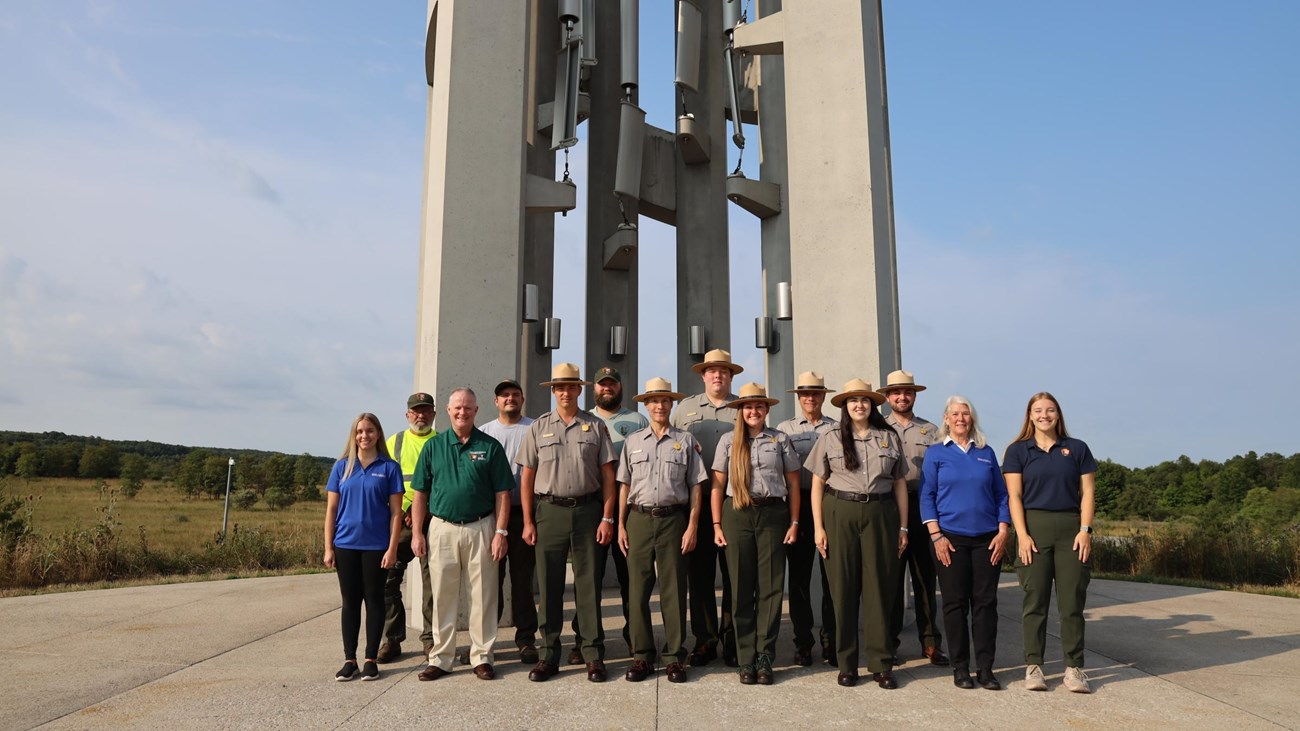 A group of staff stand in front of the Tower of Voices.