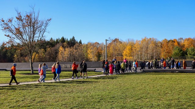 Students walking on sidewalk to the Wall of Names.