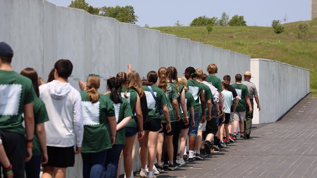 Students walking along the Wall of Names with a Ranger. 