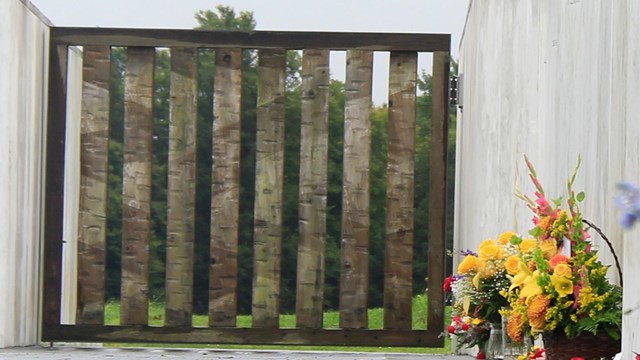 Brown gate with flowers by marble wall