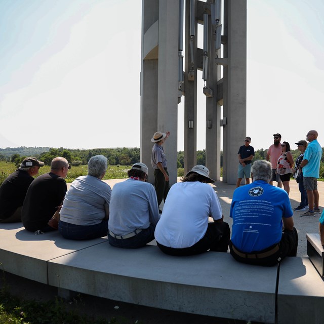 A Park Ranger speaks to visitors sitting on the benches at the Tower of Voices