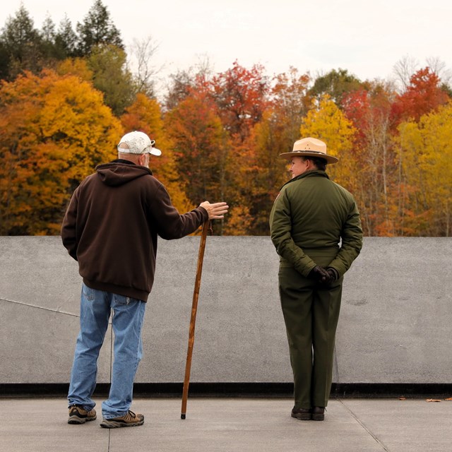 A Park Ranger speaks with a visitor at the memorial plaza.