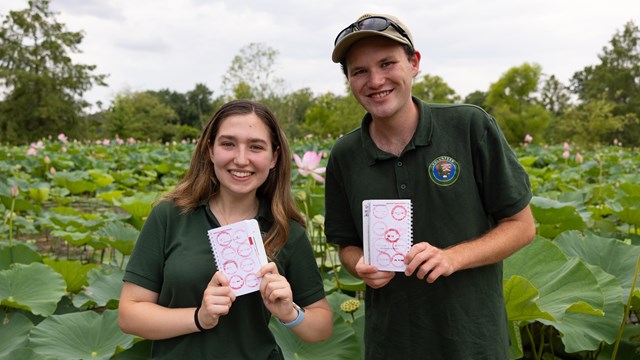 Two National Park Service interns show their passport stamp collection at Kenilworth Aquatic Gardens