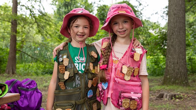 Two Junior Rangers display their Junior Ranger badge collections at Kenilworth Aquatic Gardens