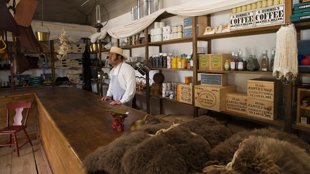 A man dressed as store clerk in a historic building