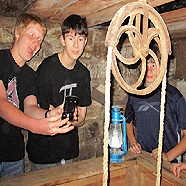 Young boys taking selfies around an underground well.