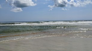 Image of ocean, beach, clouds. 