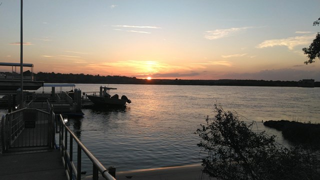 Sunset, Dock, flag pole, two boats, over water