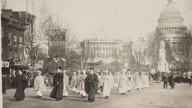 A black white photograph of nurses at a suffrage parade in front of the U.S. Capital