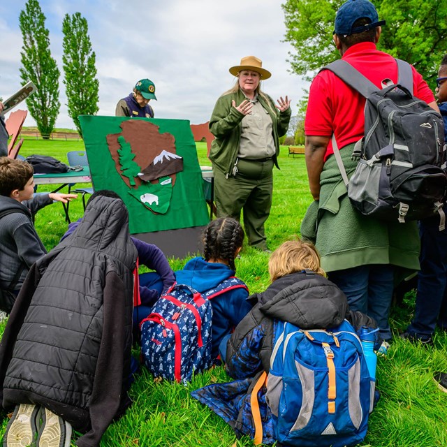 A ranger talking to a group of visitors behind the visitor center.