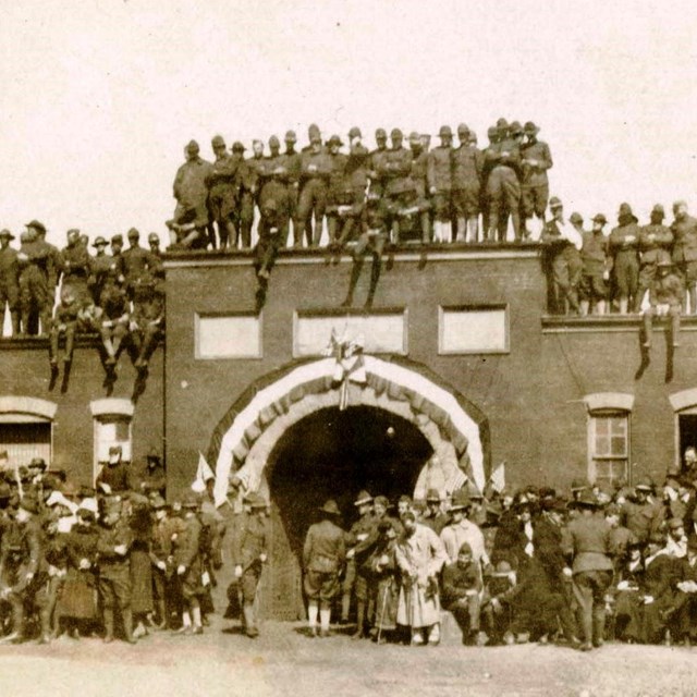 A black and white photograph showing a crowd of World War I soldiers on, and around, the sally port.