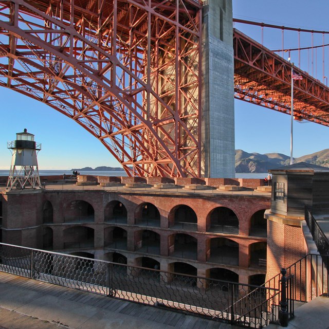 View across Fort Point Parade Ground with Golden Gate Bridge above.