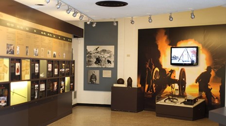 interior of visitor center, photos and artifacts displayed along the wall