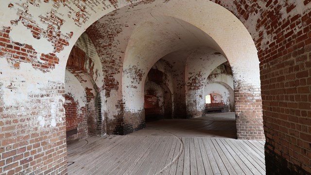 A series of brick arches with white peeling paint. 