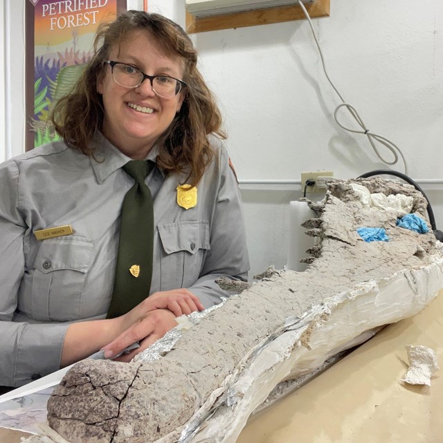 Photo of park employee with a large fossil.