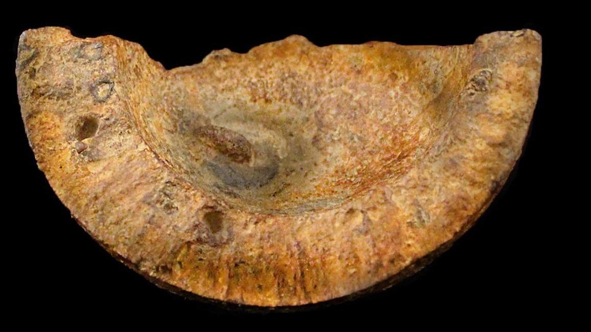 Two rusty chunks of metal that look like a broken bowling ball.