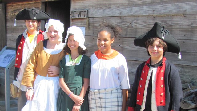 5 children dressed in various 18th C costumes.