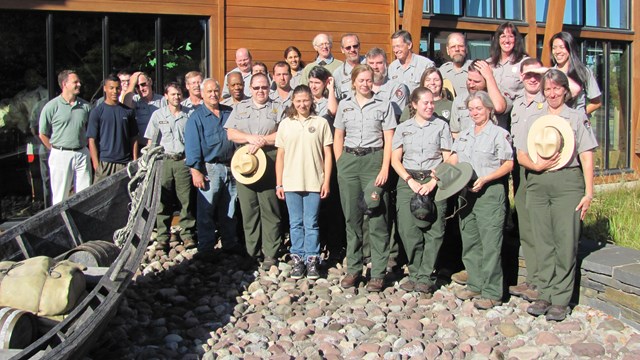 A large group of park staff gathered in front of the visitor center.