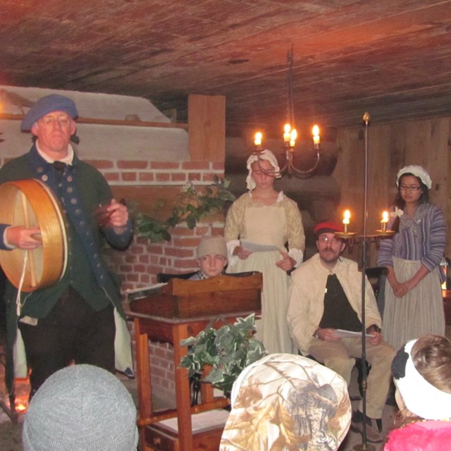From the audience you see a group of 18th C carolers. 