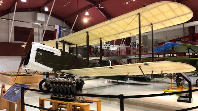 A photo of a DH-4 Liberty plane, a large biplane, inside Pearson Air Museum.