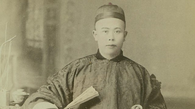 A black and white portrait of a Chinese man wearing traditional clothing.