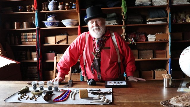 Two park rangers stand in front of the Contact Station at Fort Vancouver.