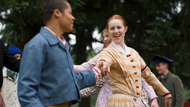 Costumed 19th century re-enactors demonstrate a historic dance