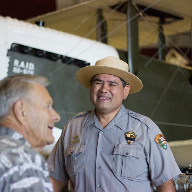 A park ranger stands in front of an aircraft at Pearson Air Museum.
