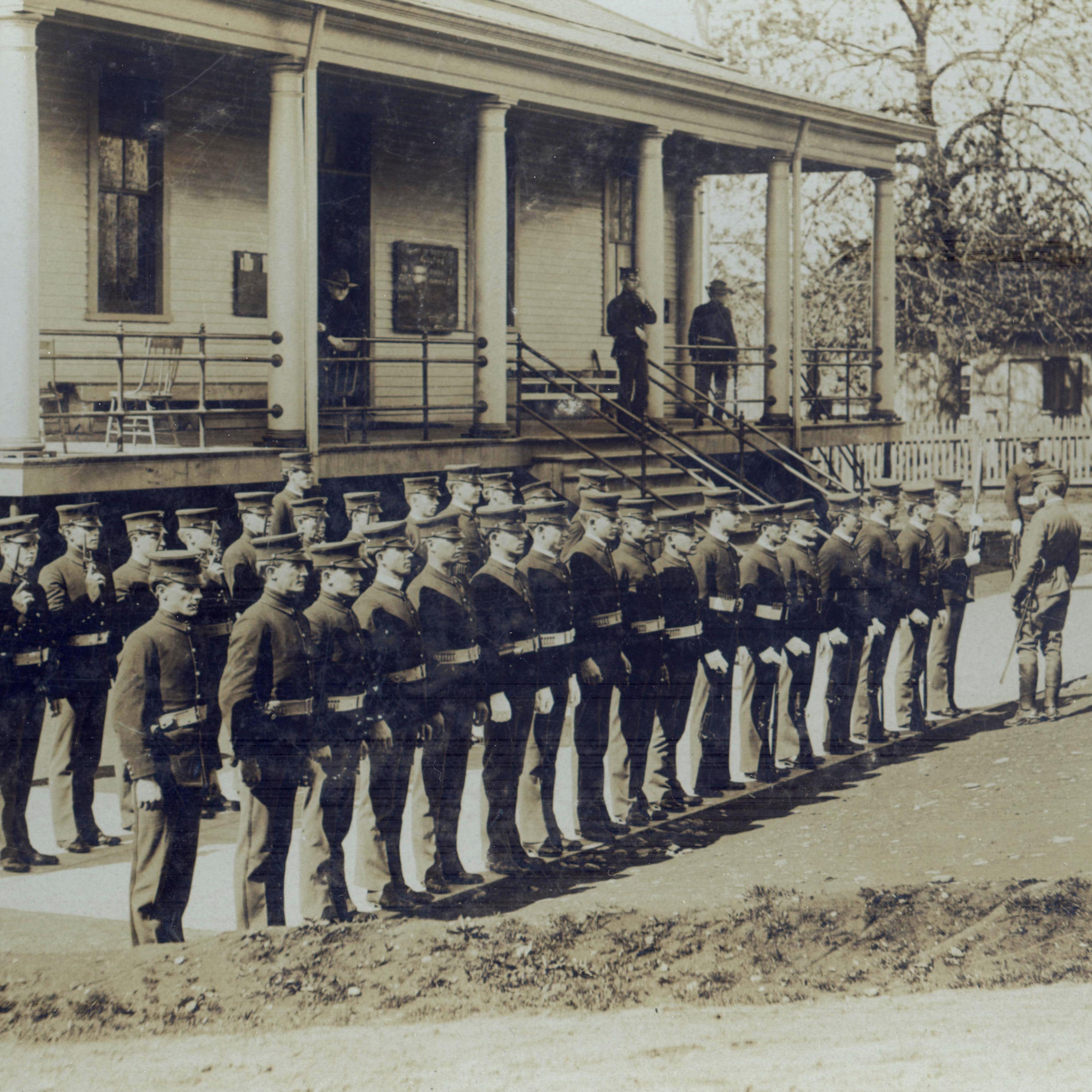 Historic photograph of soldiers standing in front of a building at Vancouver Barracks
