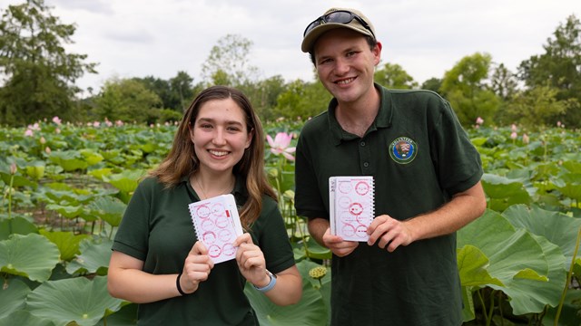 Two National Park Service interns show their passport stamp collection at Kenilworth Aquatic Gardens