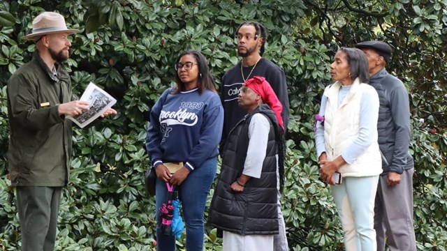 Park Ranger stands outside with people 