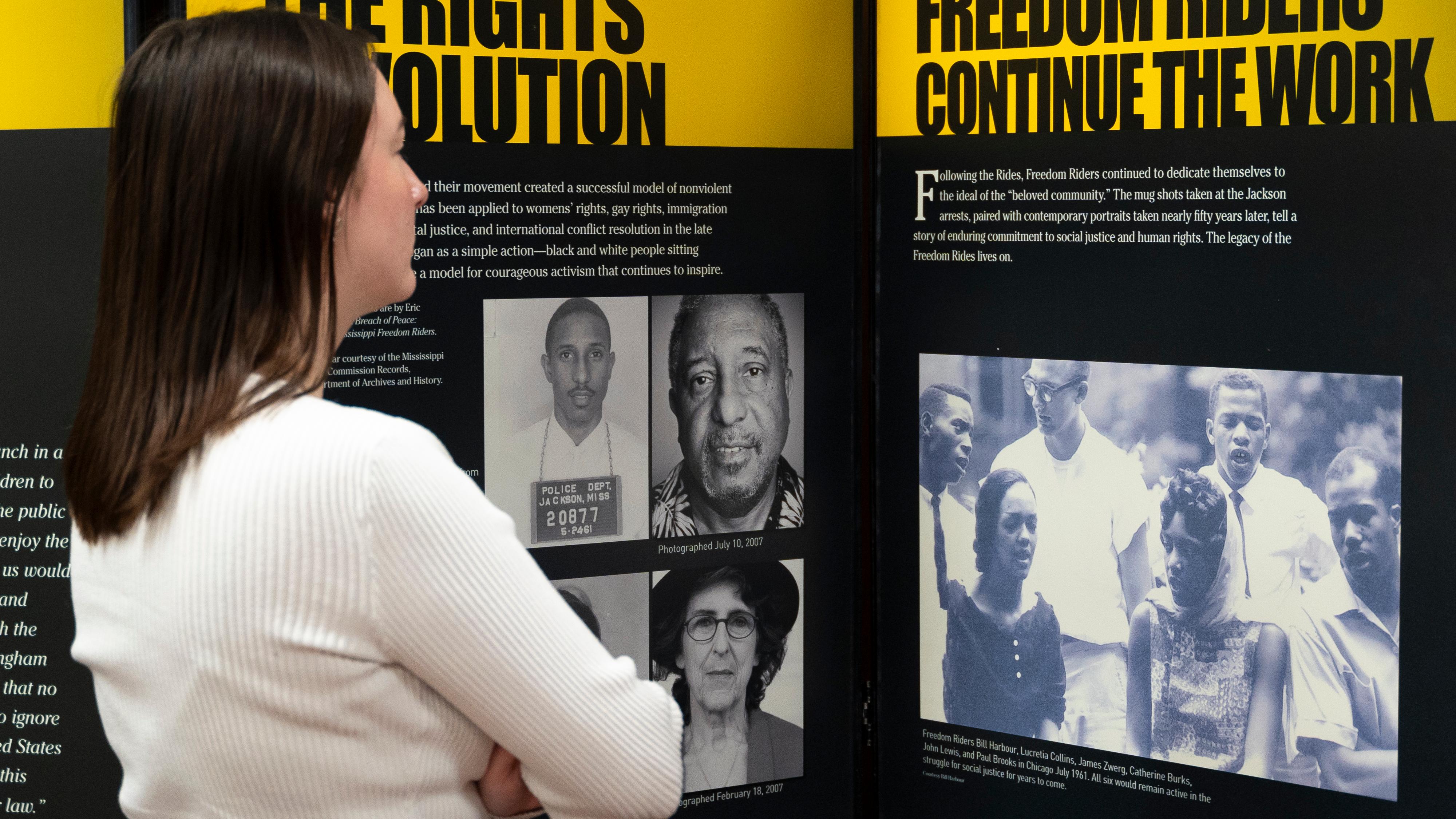 A woman studies a photo of people marching.