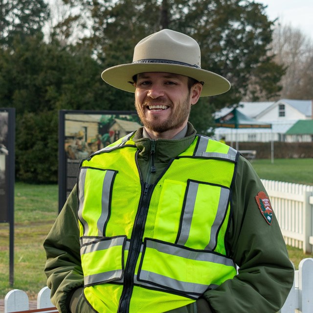 A law enforcement ranger smiles at the camera