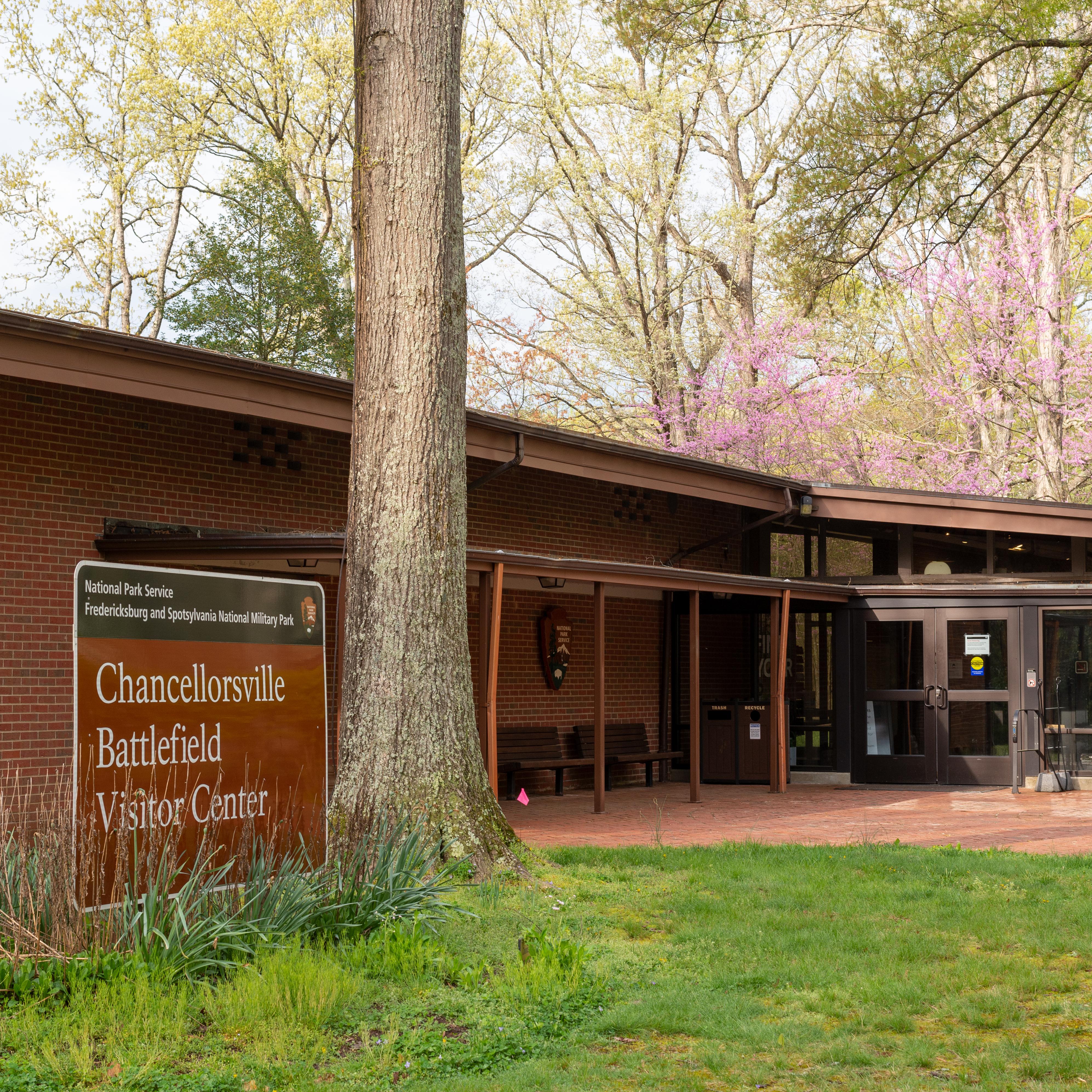 A single story brick building with entrance sign in front.
