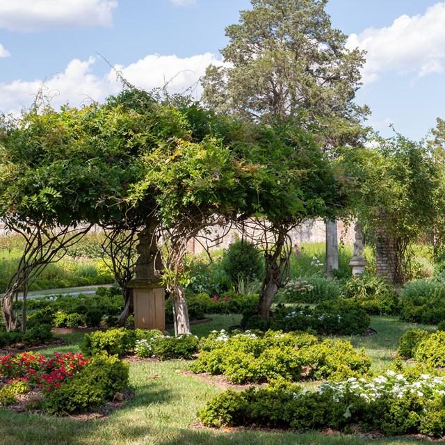 Overgrown gardens with statuary and paths.