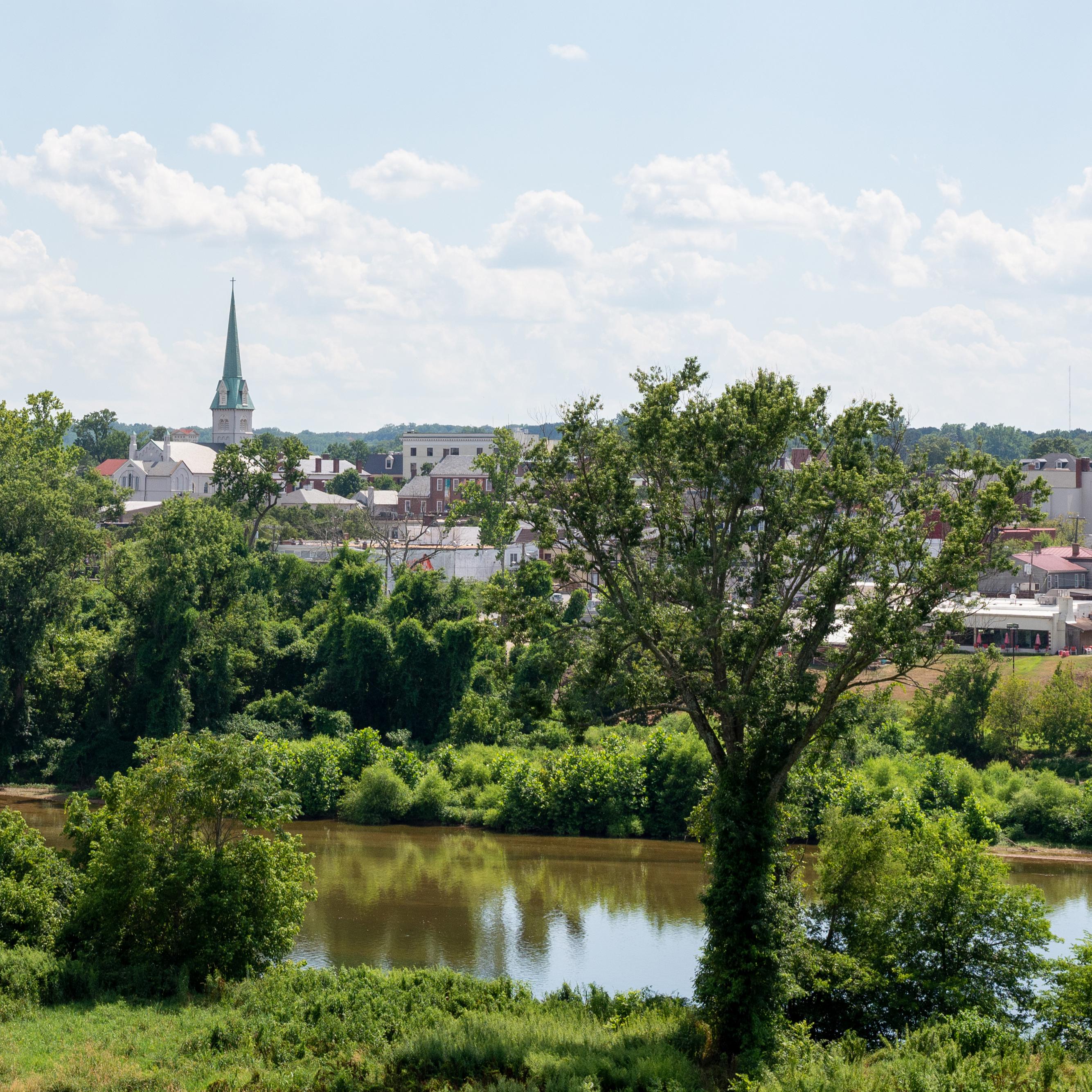 View across a river of city on sunny day.