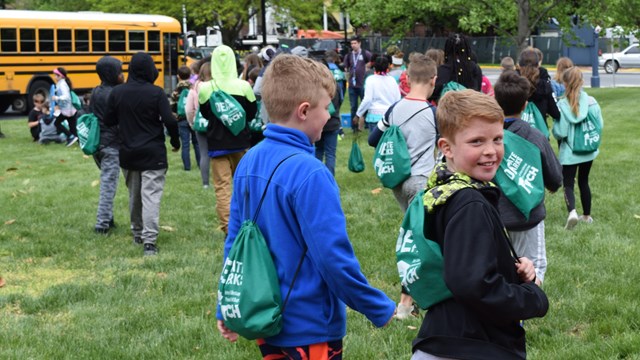 A group of kids walk to get on their bus near The Dover Green. 