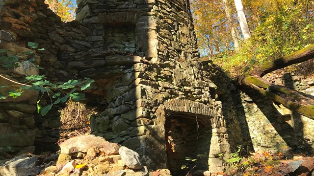 Remnants of an old stone chimney in the woods. 